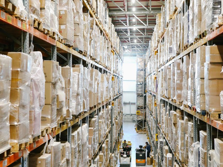 Regallager-Gang mit folienverpackter Ware auf Paletten
