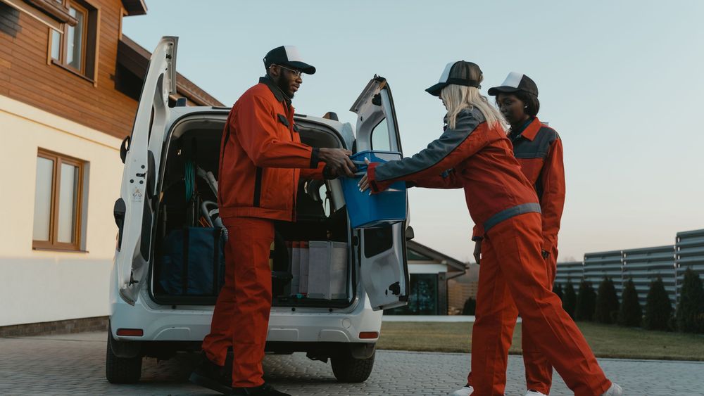 Umzugsteam steht vor einem Transporter und bespricht den Ablauf des anstehenden Umzugs